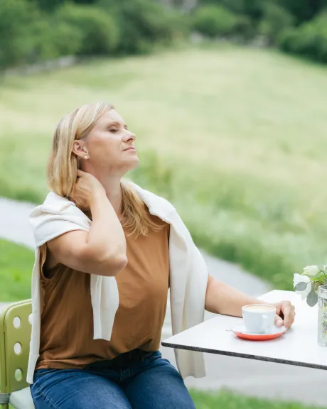 Frau hält sich den Nacken