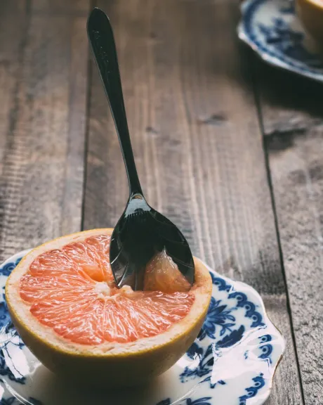 Graipfruit mit Löffel auf einem Teller