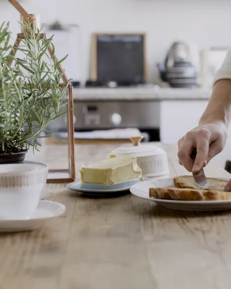 Frau schmiert ein Brot mit Butter