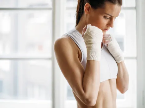 Frau in Sportkleidung mit Armbandagen