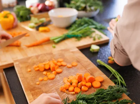 Karotten und Kräuter werden geschnitten