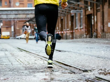 Mann mit Regenjacke joggt durch die Stadt