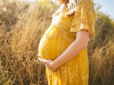 Schwangere Frau mit gelbem Kleid