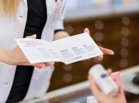 apothekerin hält broschüre in der hand und berät