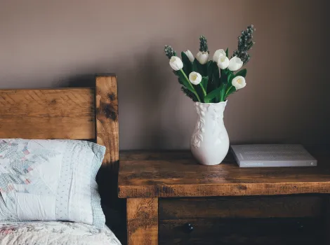 Eine Blumenvase auf einem Nachtkästchen