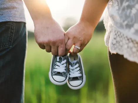 Paar hält Babyschuhe in der Hand