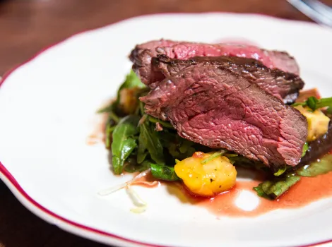 Steak mit Ruccola, Kartoffeln und Soße auf einem Teller