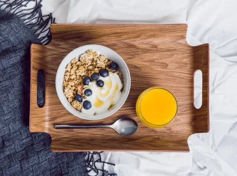Müsli Joghurt Heidelbeeren Blaubeeren Orangensaft Bett blau grau dunkelblau weiß Frühstückstablett Löffel Decke Gesunde Ernährung
