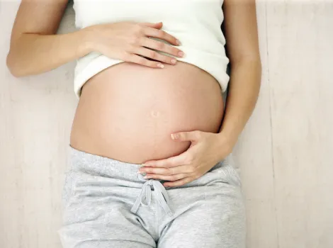 Frau hält ihren Schwangerschaftsbauch