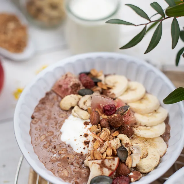 Porridge mit Bananen, Cashewbüssen, Kürbiskernen und weiteren Nüssen und Samen