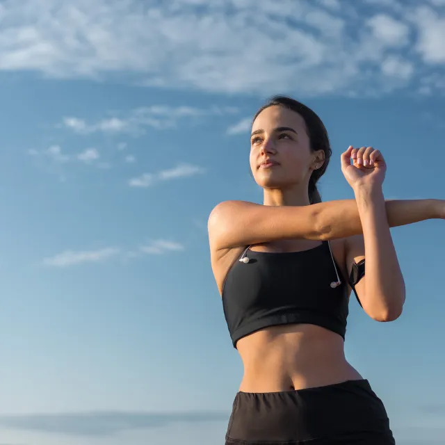 Frau dehnt sich im Sportoutfit