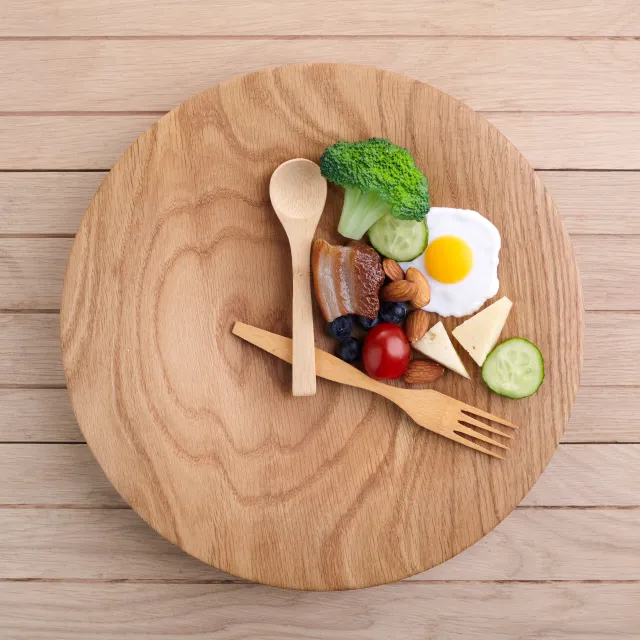 Holzbrett mit Besteck als Uhrzeit mit Essen