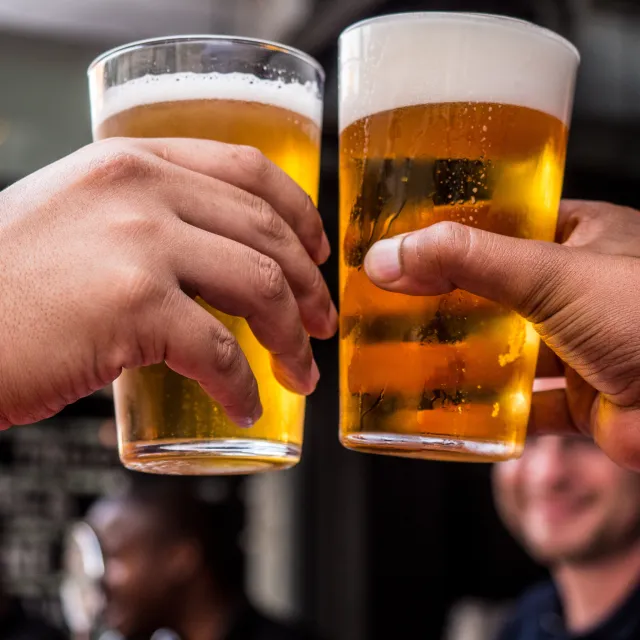 Zwei Männer stoßen mit Biergläsern an