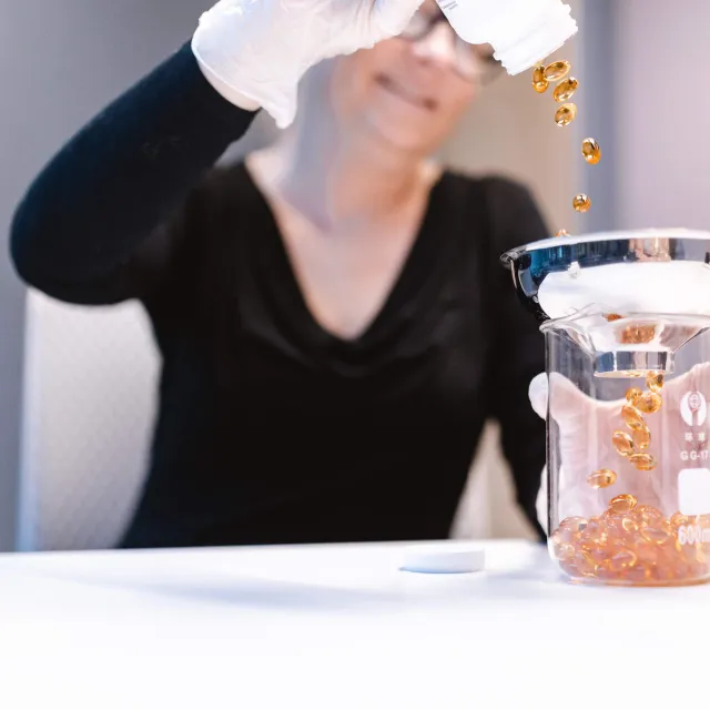 Pure Kapseln werden in Glas gefüllt