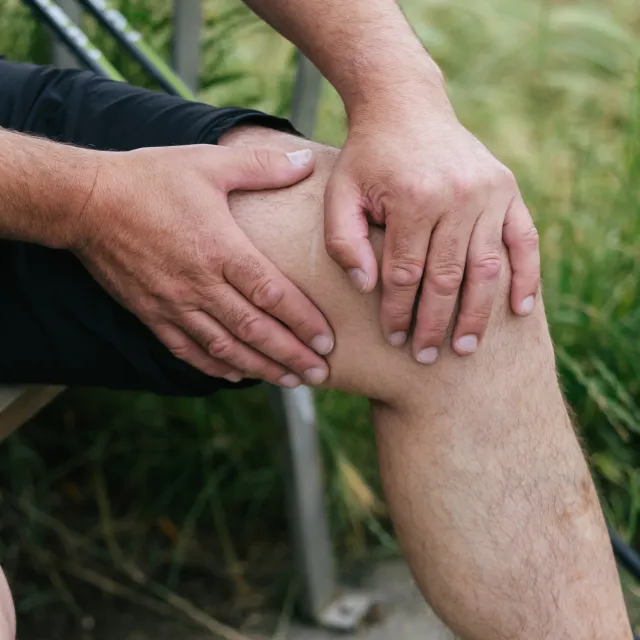 Mann hält sein Knie
