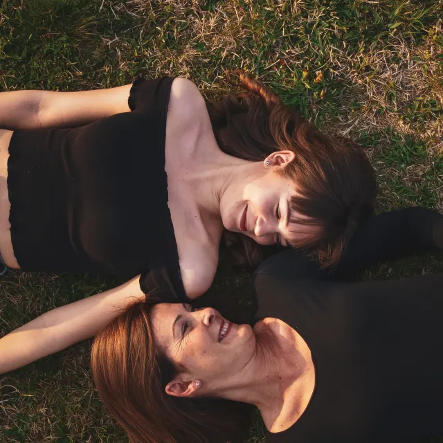 Zwei Frauen liegen auf einer Wiese