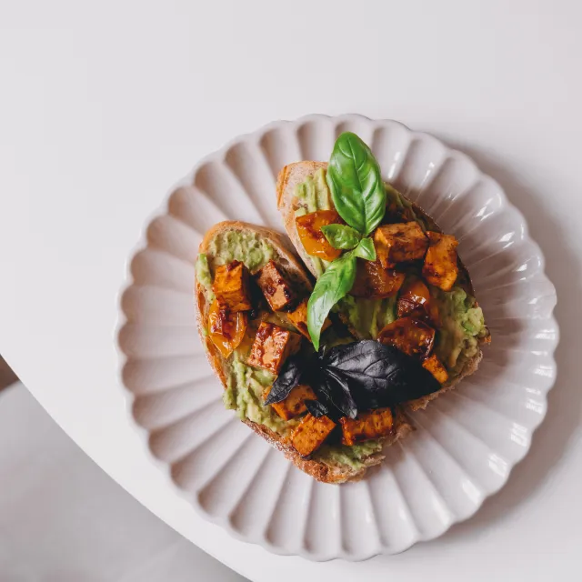 Zwei vegane Brote mit Avocadoaufstrich und getrockneten Tomaten