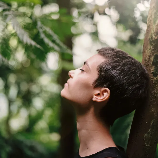 Frau mit geschlossenen Augen im Wald