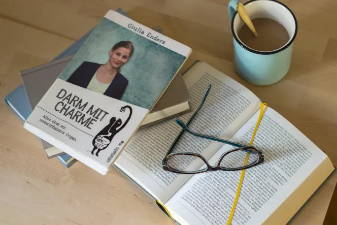 Buch "Darm mit Charme" von Giulia Enders und eine Brille und Tasse Kaffee