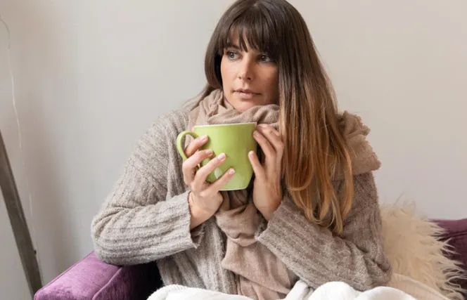 Frau mit Schal und Tasse in der Hand