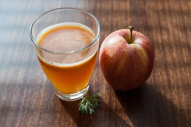 ein Glas Apfelsaft mit Apfel daneben