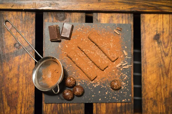 Raw Energy-Bites auf Schieferplatte mit Kakaopulver bestäubt