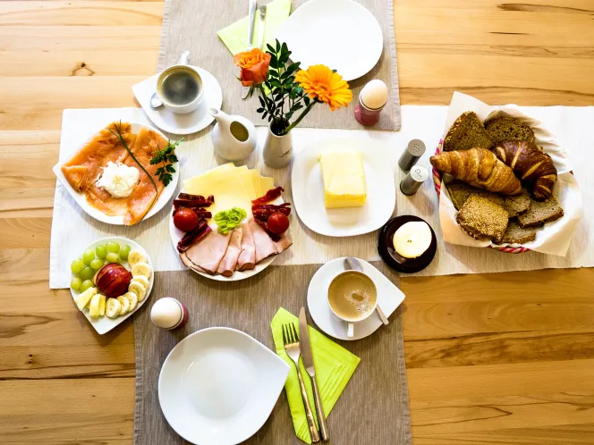 Frühstückstisch mit Butter, Käse, Wurst und Eiern