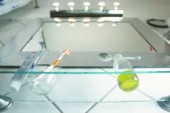 Eine Glasflasche mit Öl und einem Löffel auf einem Regal neben einer Zahnbürste und Zahnpasta