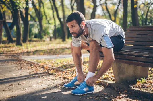 Mann mit blauen Sneakers sitzt auf einer Bank