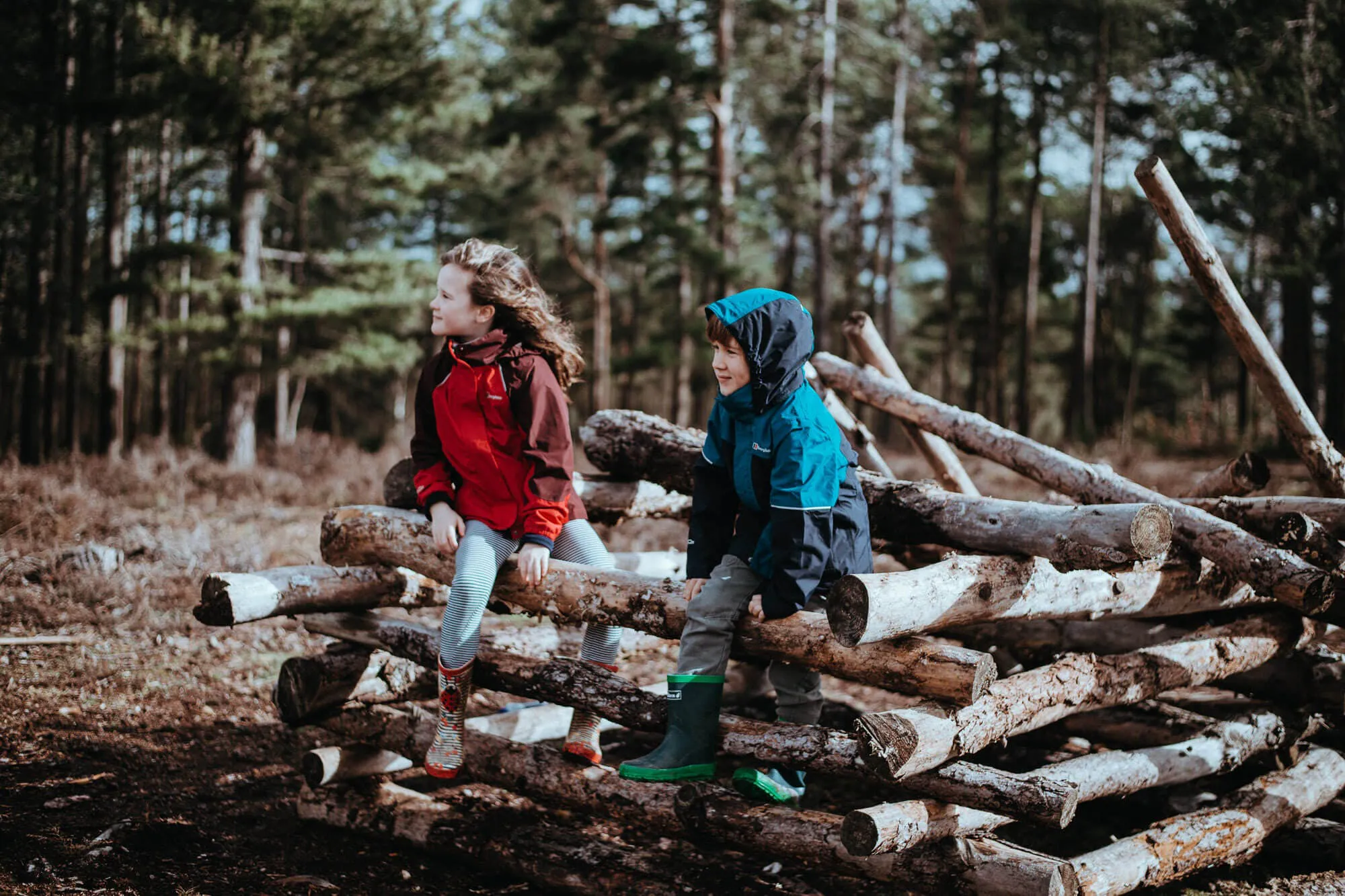 Kinder sitzen auf Ästen im Wald