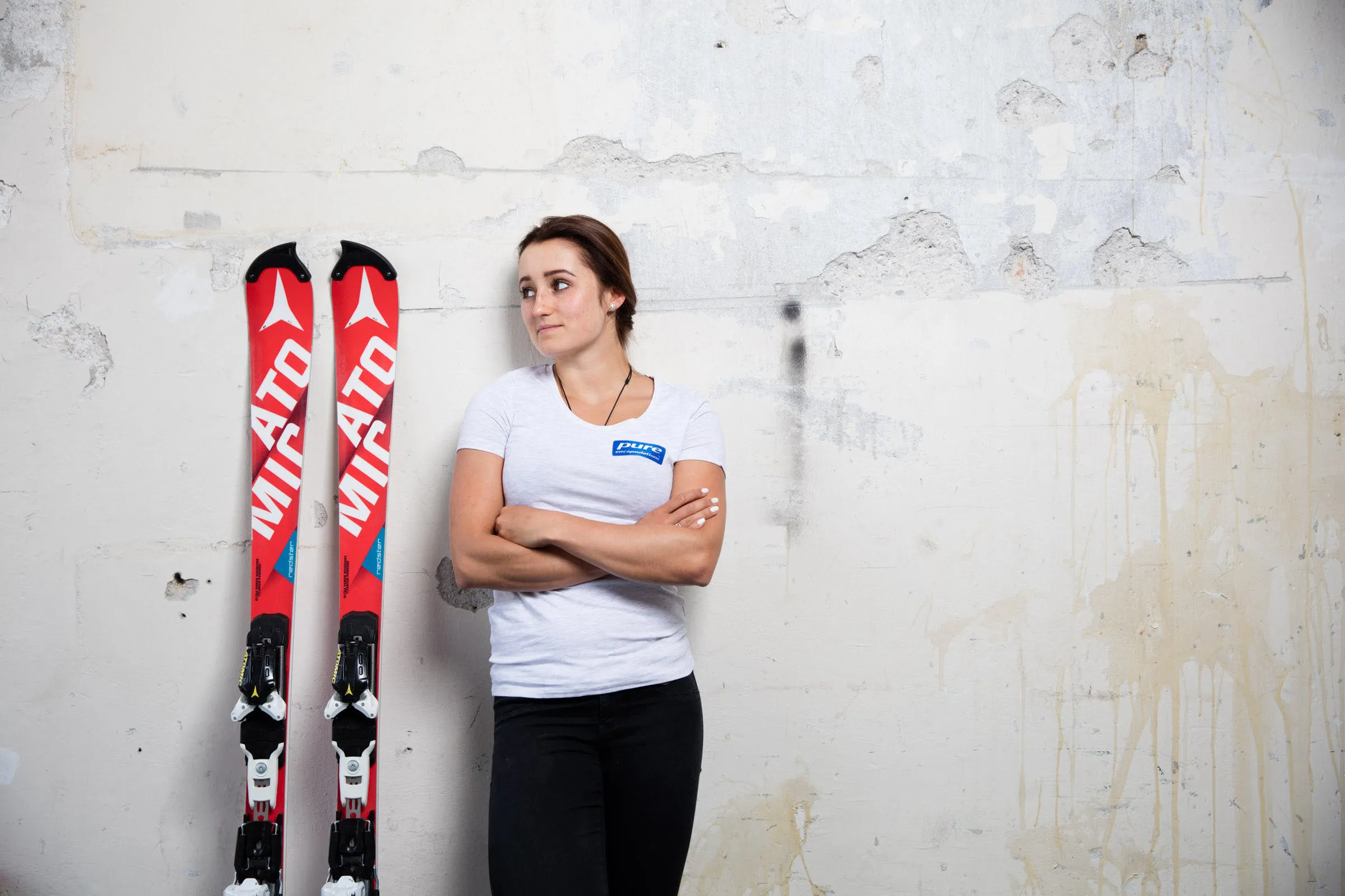 Chiara Mair lehnt neben Atomic Ski an der Wand