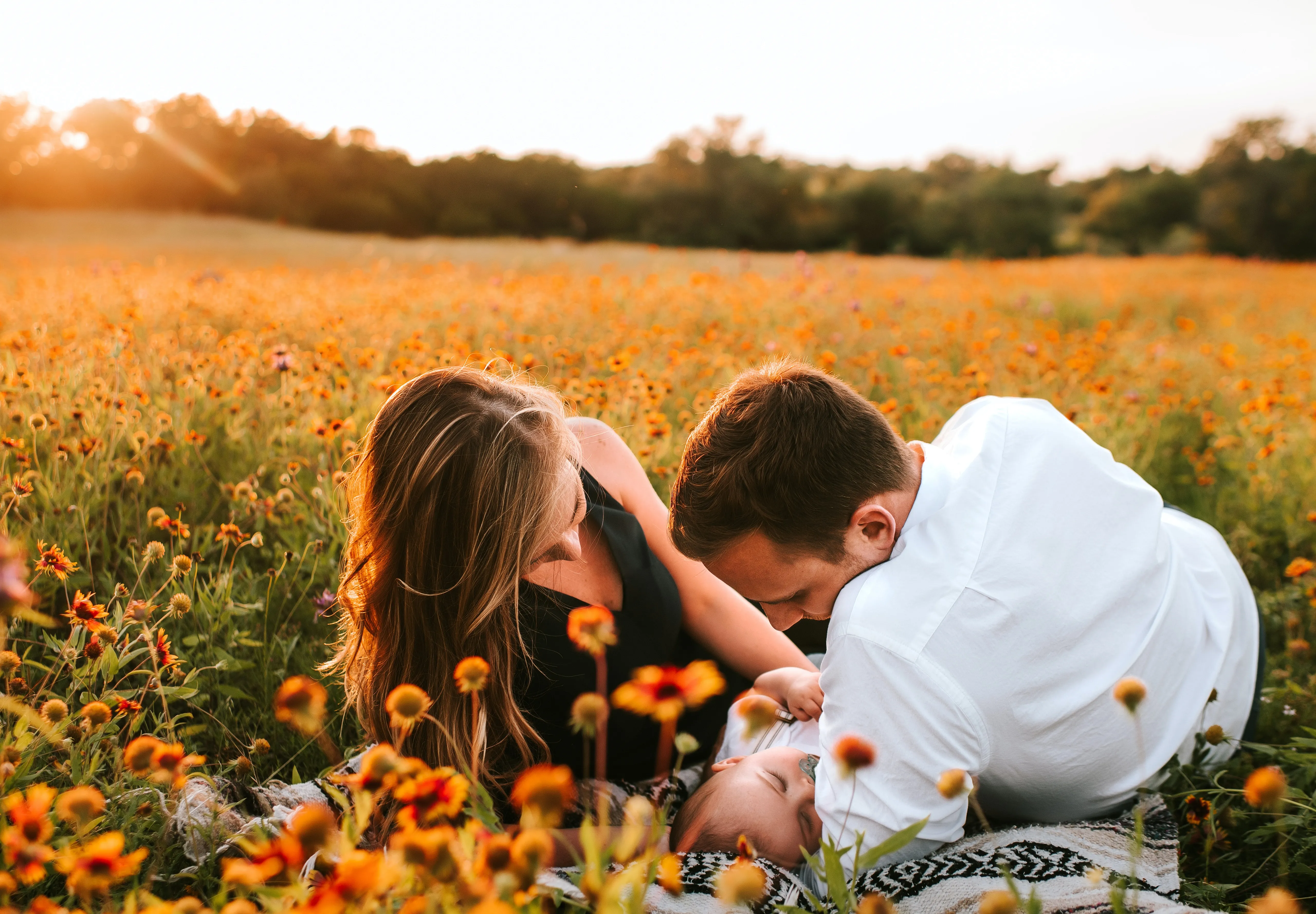 Paar mit Baby auf Blumenwiese