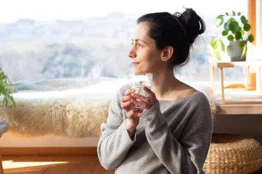 Schwangere Frau trinkt ein Glas Wasser