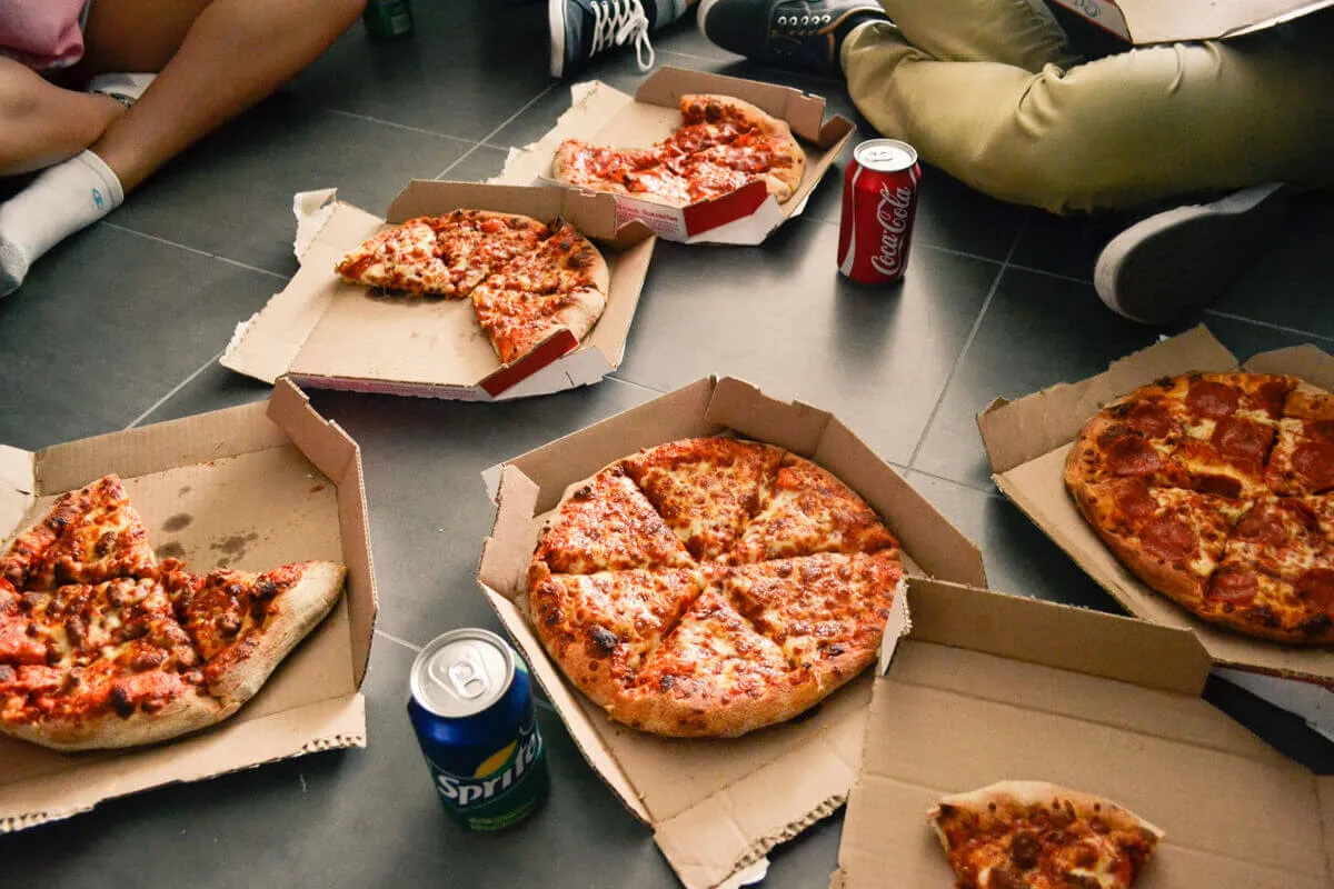 Fünf Pizzen in Kartons mit einer Cola und Sprite Dose