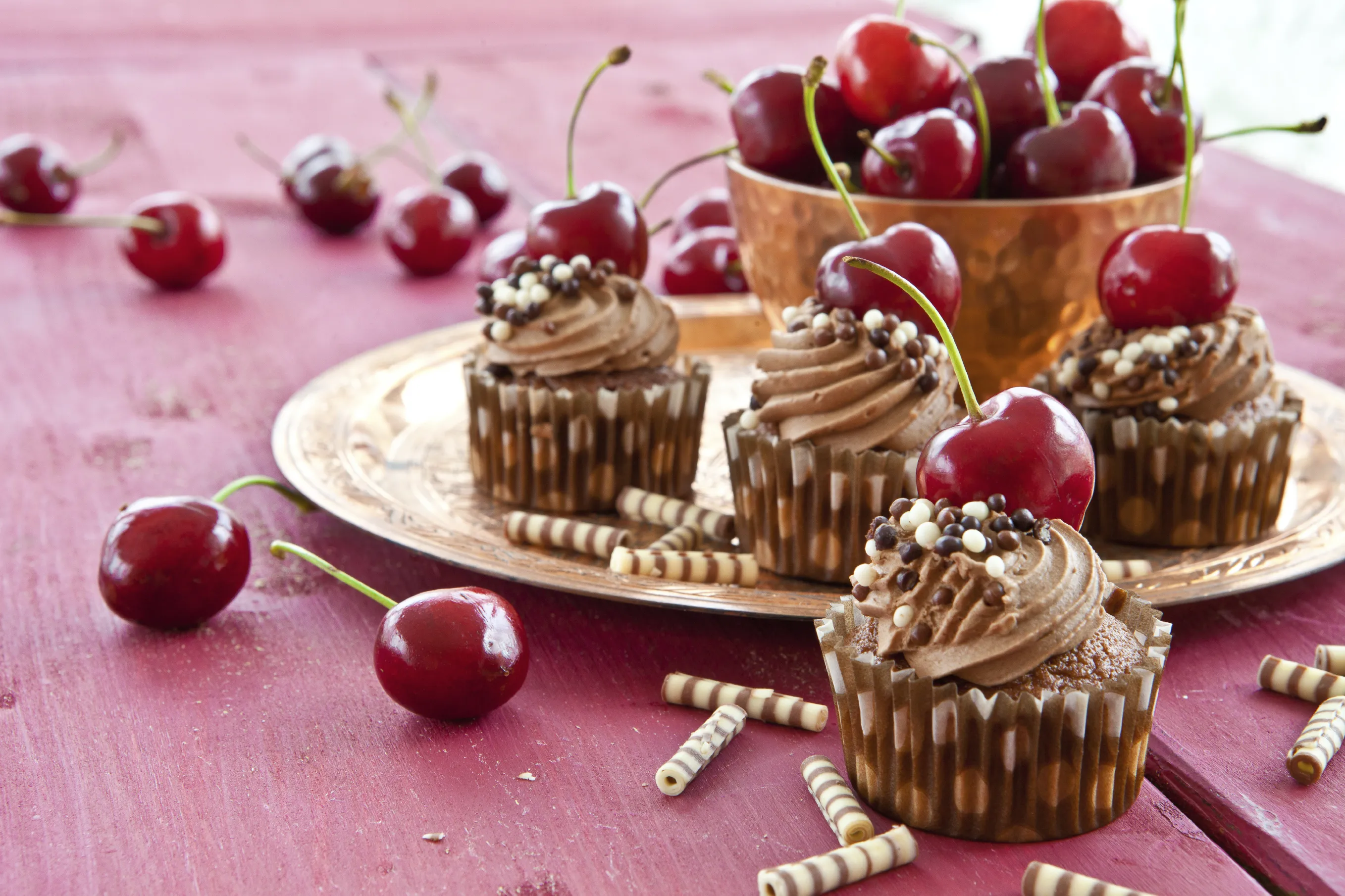 Schoko Cupcakes mit einer Kirsche und Schokoröllchen