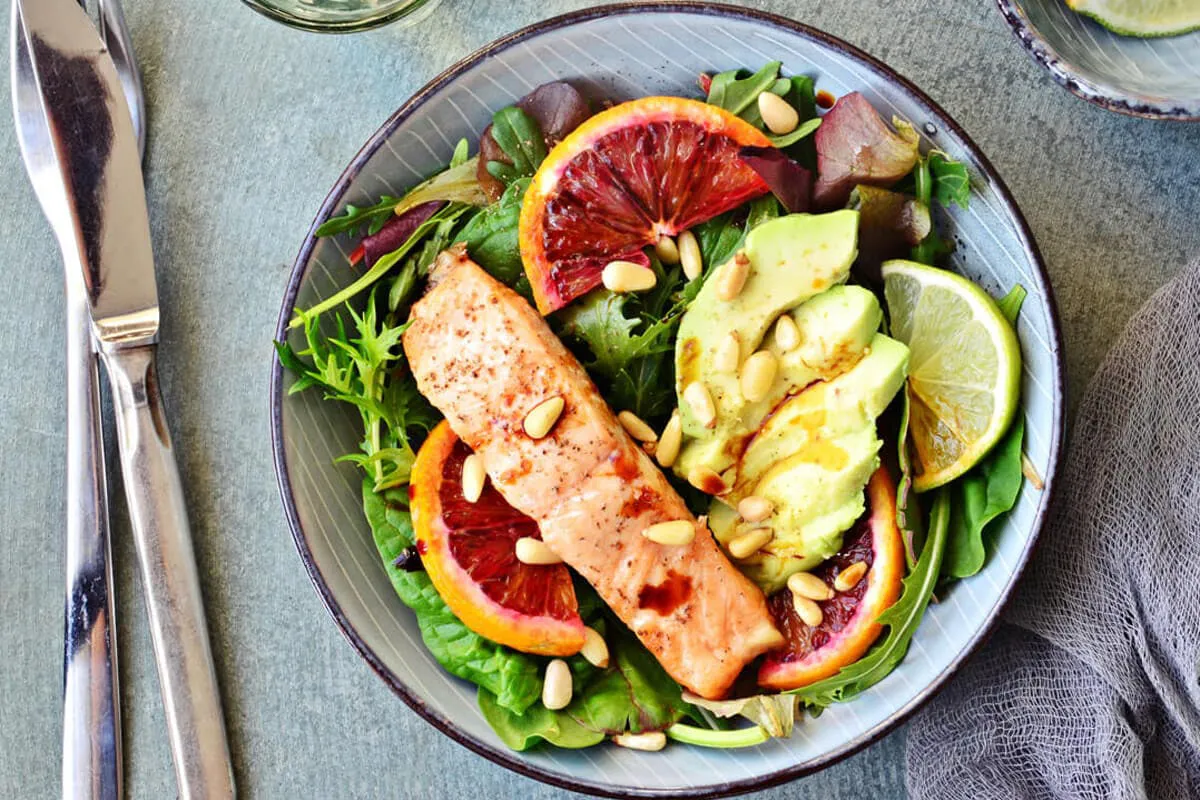 Lachs auf einem Salatteller mit Gemüse und Samen