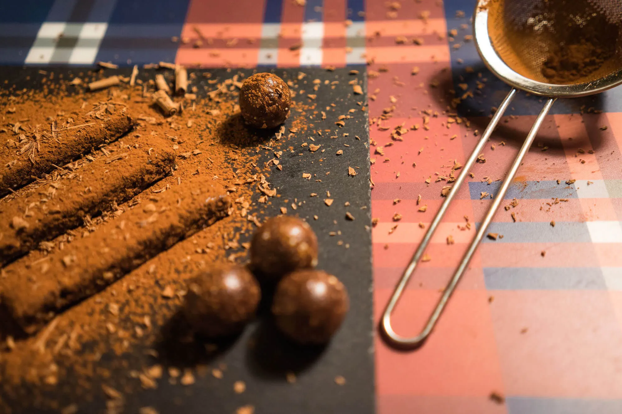 Raw Energy-Bites auf Schieferplatte mit Kakaopulver
