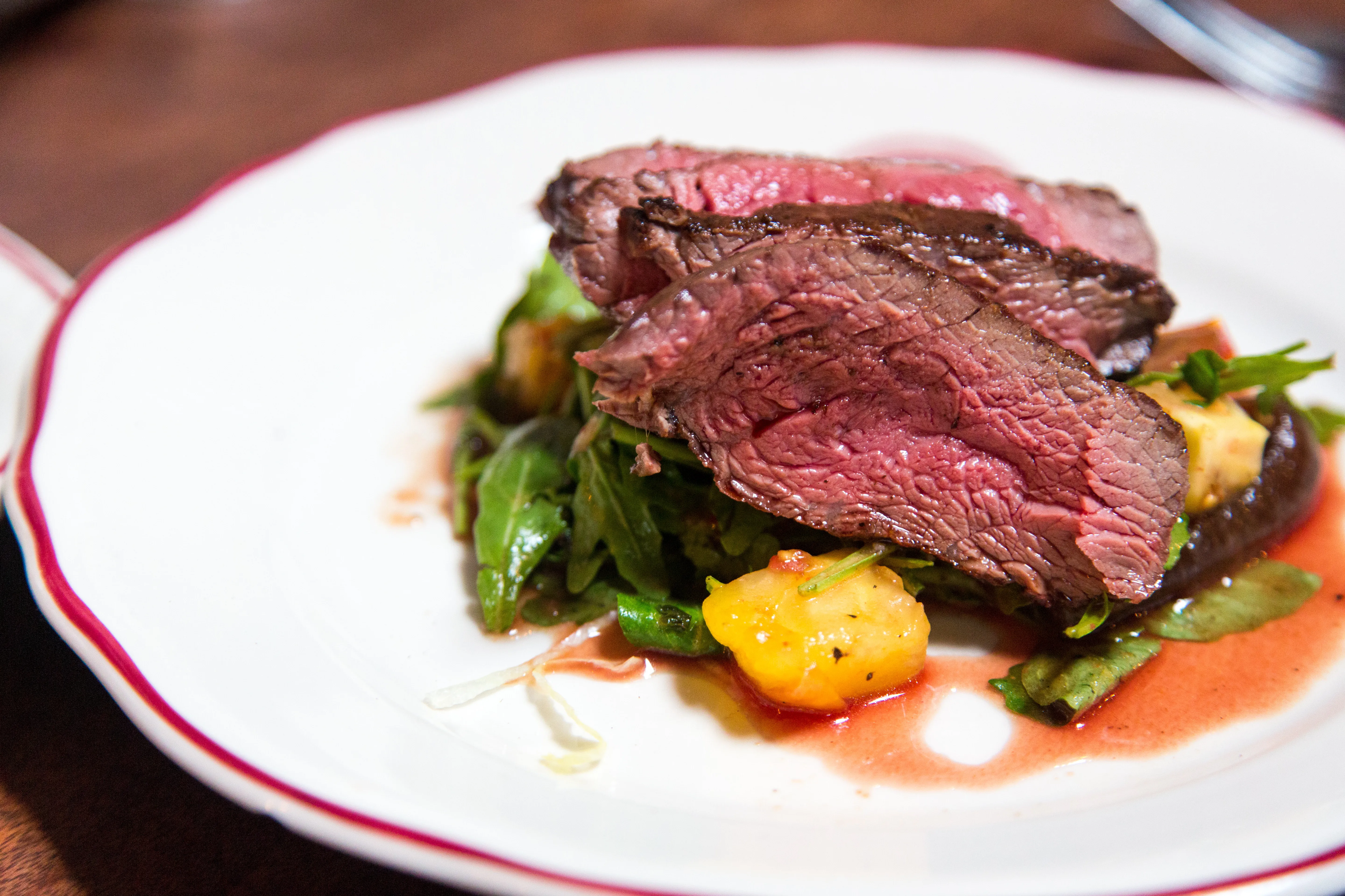 Steak mit Ruccola, Kartoffeln und Soße auf einem Teller