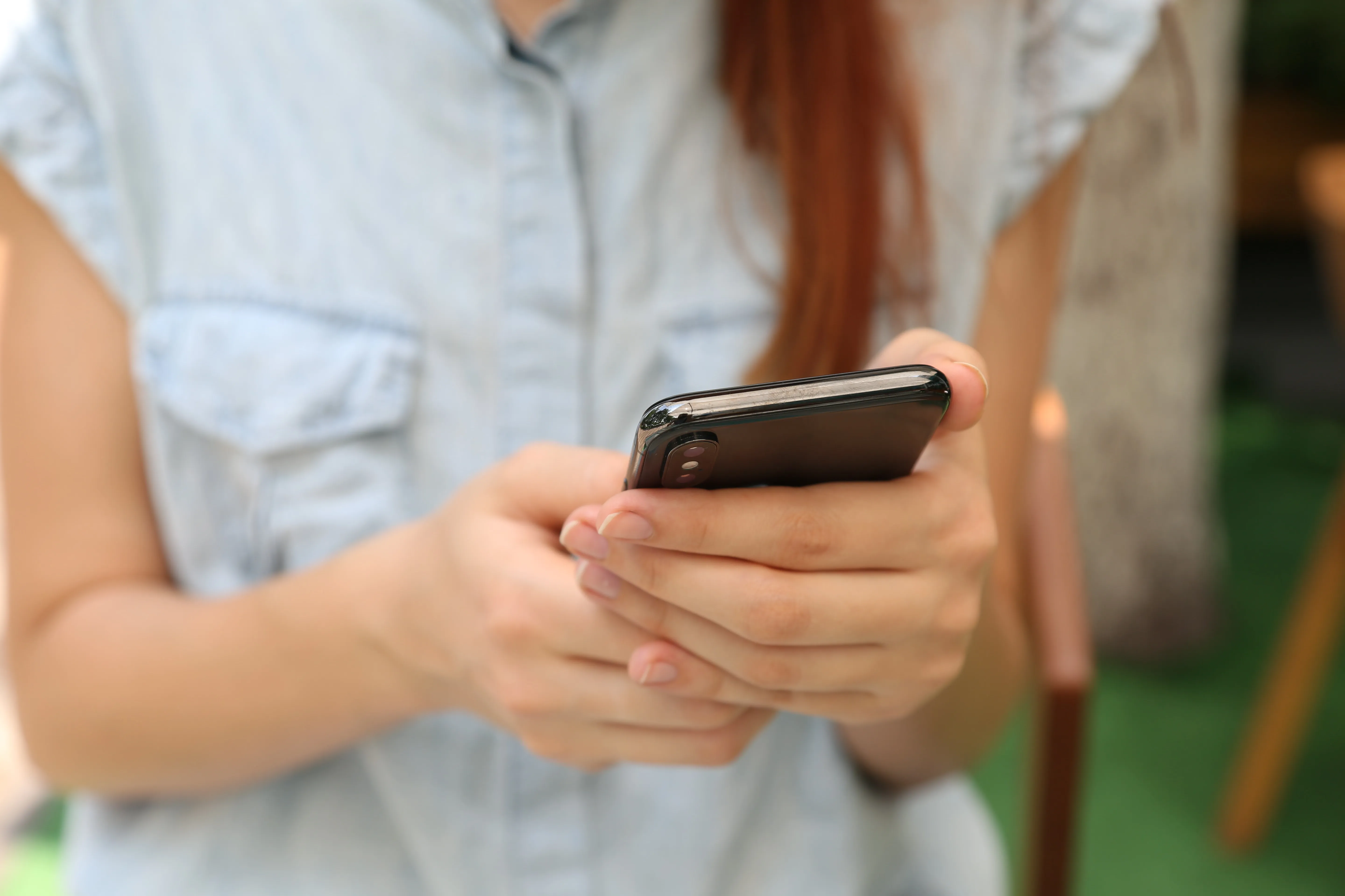 Frau hält ihr Smartphone in der Hand
