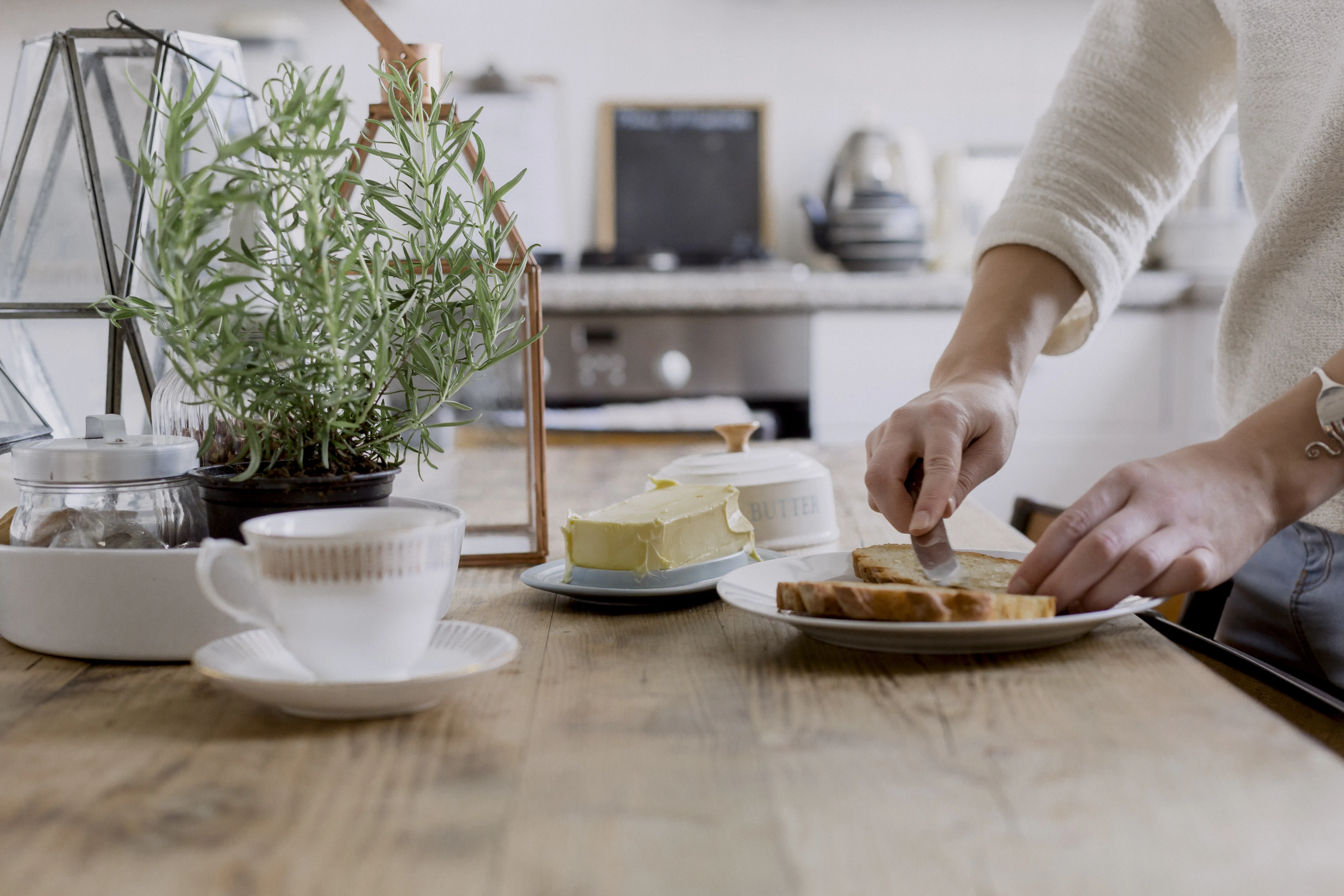 Frau schmiert ein Brot mit Butter