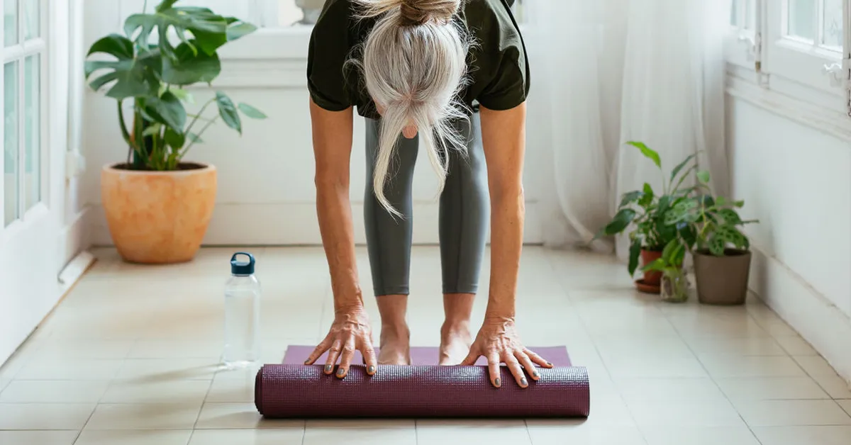 Ältere Frau mit Yoga Matte