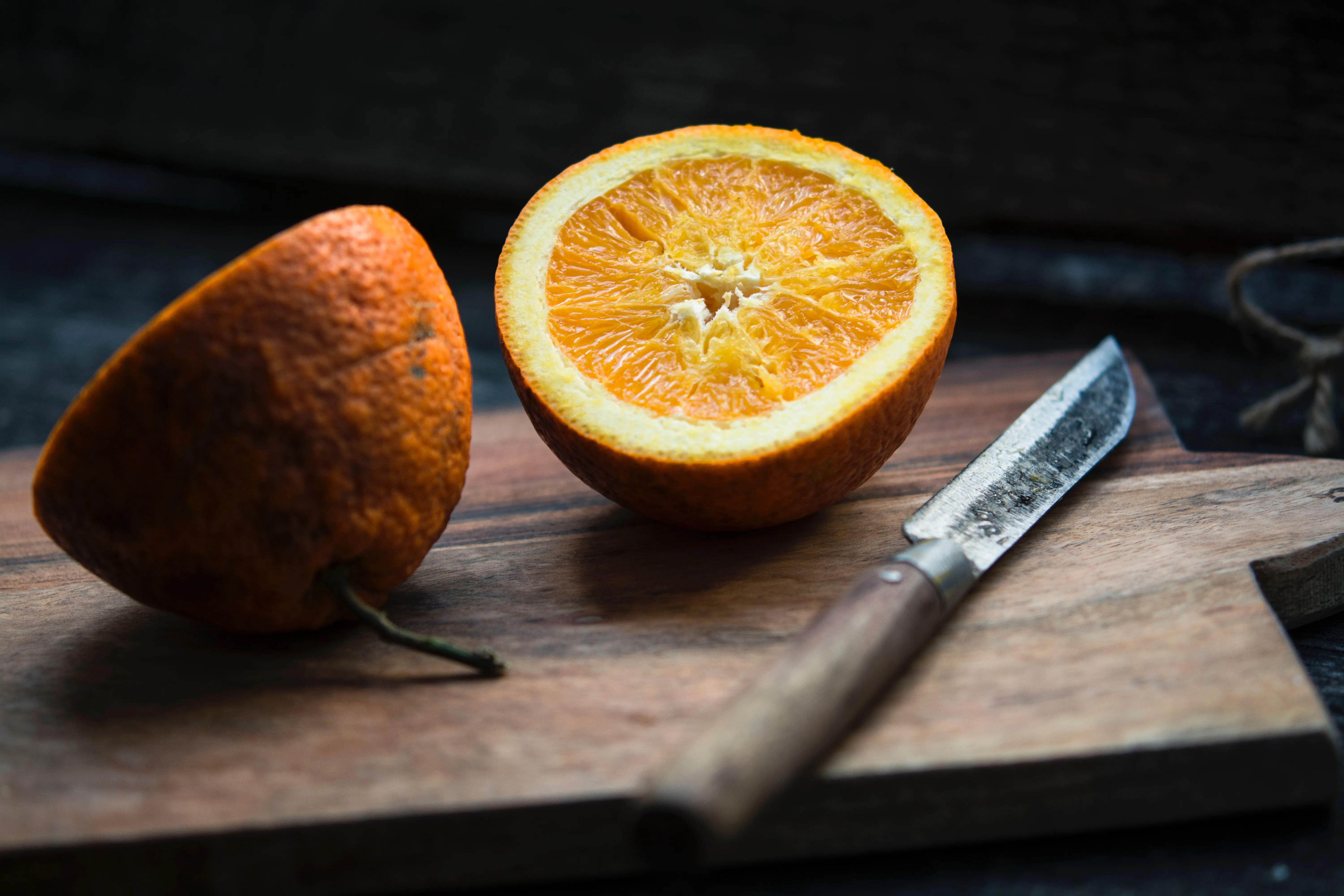 Eine aufgeschnittene Orange neben einem Messer