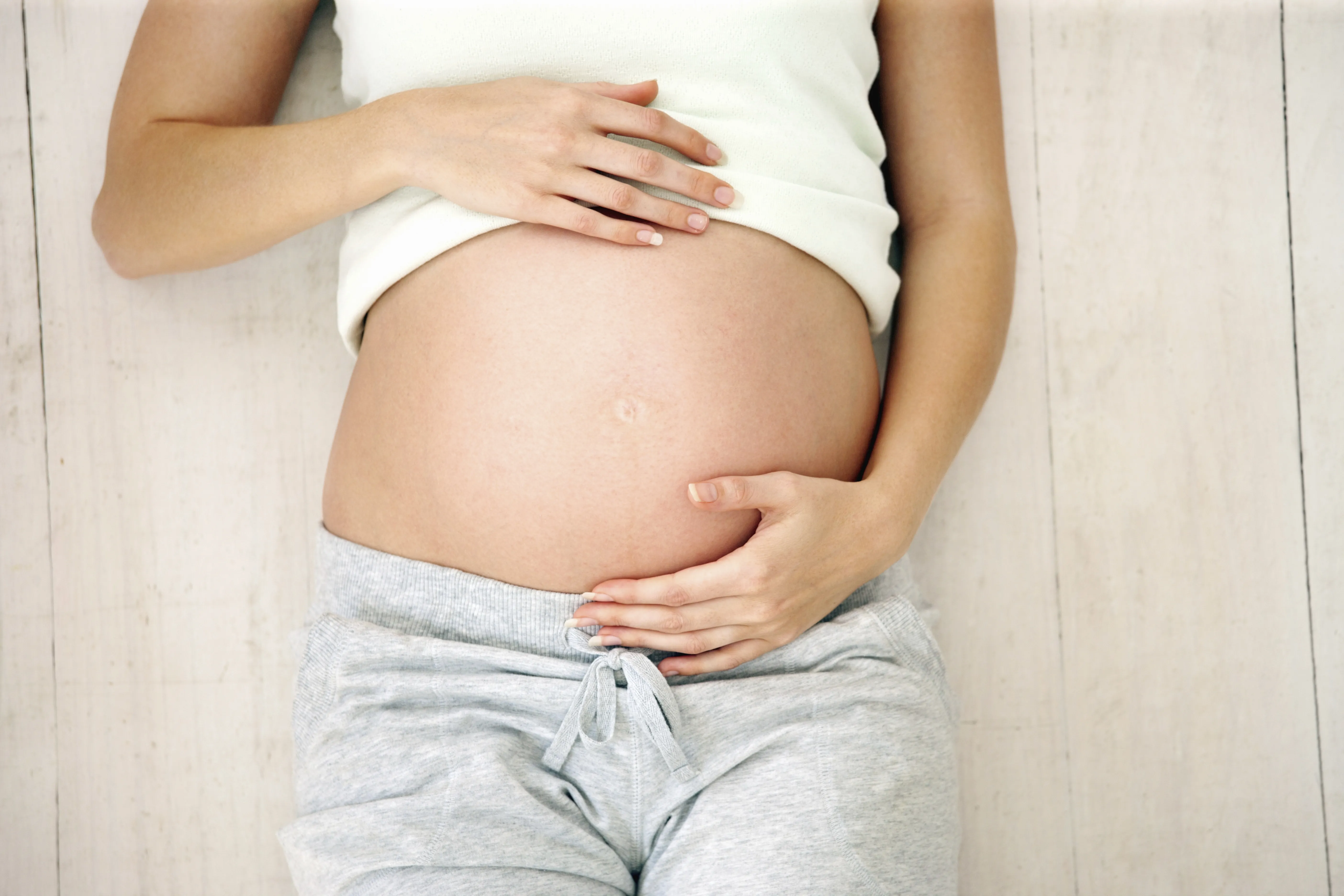 Frau hält ihren Schwangerschaftsbauch